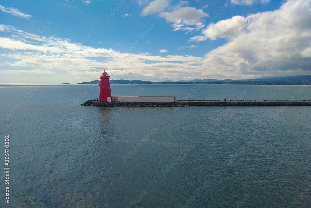 View of the red Poolbeg lighthouse in the sea.