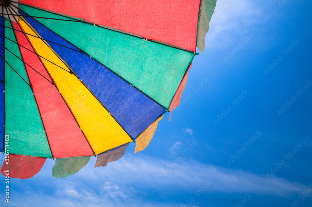 Colorful beach umbrella with blue sky