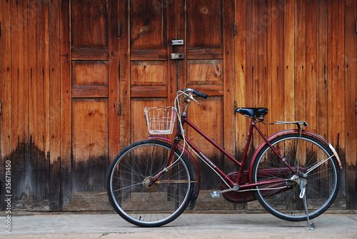 Classic bicycle in front of the wooden house, Loei, Thailand.