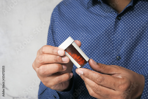 young man holding pill contianer with copy space  photo