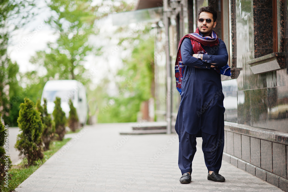 Stylish pakistani indian muslim arabic man in kurta dhoti suit and sunglasses.