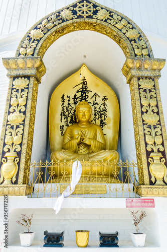 Gilded Buddha statue at the World Peace stupa, Pokhara, Nepal photo