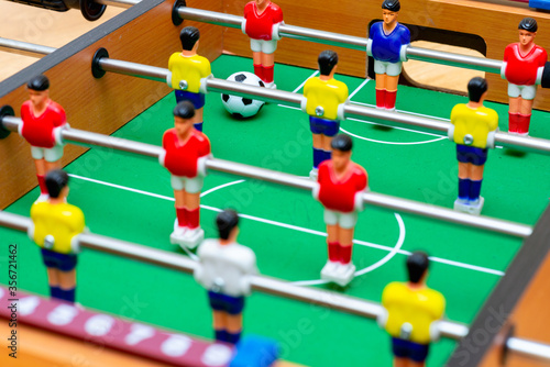 Close up table soccer with players and a ball.