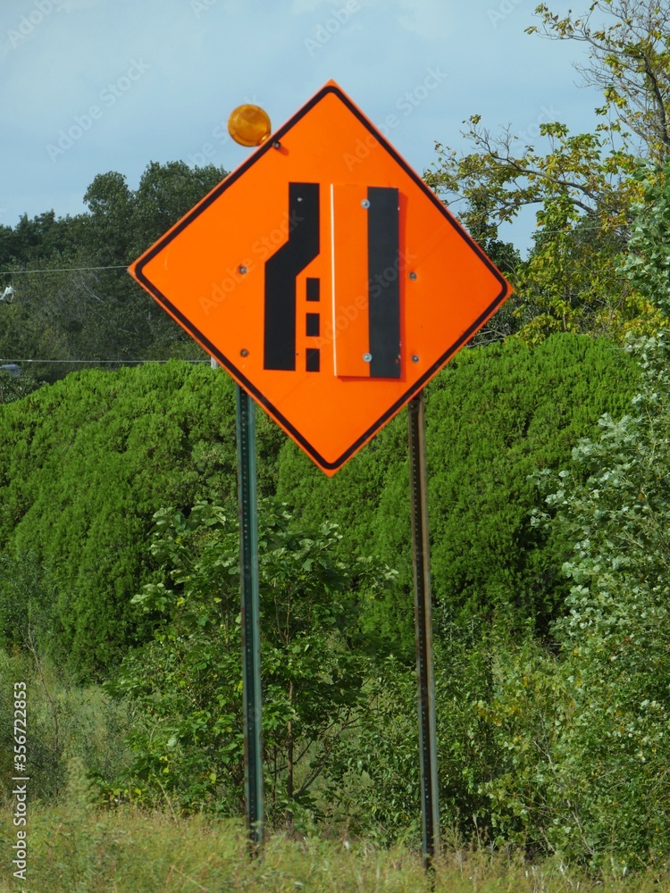 Road sign warning drivers that the lane will end and merge. This is usually posted on the road where construction or road repair is in progress.