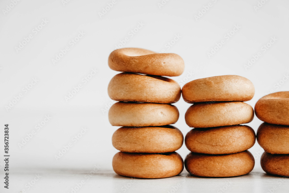 Drying or mini round bagels in the shape of a tower on a white wooden background. Copy, empty space for text Drying or mini round bagels in the shape of a tower on a white wooden background. Copy, empty space for text