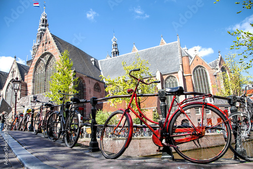 bicycle, symbol of Amsterdam, Netherlands in front of the Oude Kerk (Old Church) from across the Oudezijds Voorburgwal canal photo