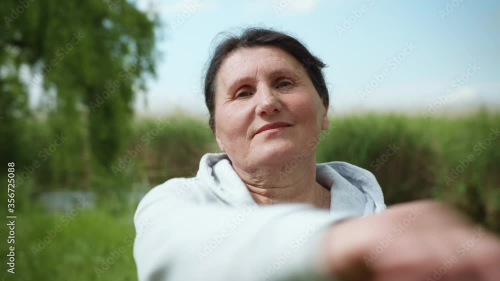 old smiling woman leads to take care of her health and leads sporty lifestyle, elderly female is engaged in sports to support outdoor health by river old smiling woman leads to take care of her health and leads sporty lifestyle, elderly female is engaged in sports to support outdoor health by river
