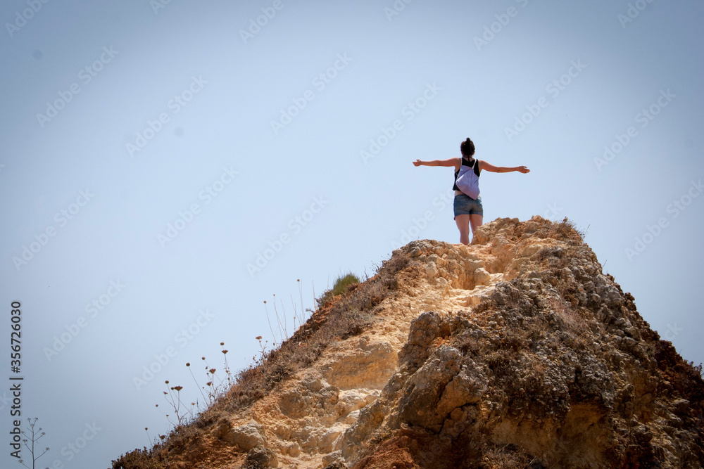 Mujer joven con los brazos abiertos saludando al sol Mujer joven con los brazos abiertos saludando al sol