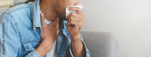 crop view asian man use tissue cover mouth during sneeze have allergy photo