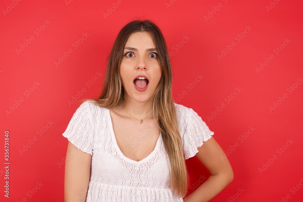 Attractive young woman having stunned and shocked look, with mouth open and jaw dropped, listening to friend's story in full disbelief, exclaiming: Wow, I can't believe this. Surprised girl. Shock Attractive young woman having stunned and shocked look, with mouth open and jaw dropped, listening to friend's story in full disbelief, exclaiming: Wow, I can't believe this. Surprised girl. Shock