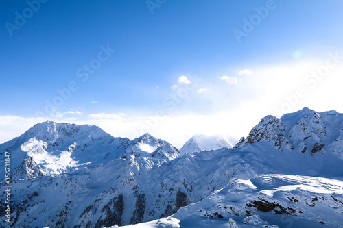 Beautiful jagged rocky mountains of the Alps with large depth of field. Sunny blue-sky skiing day. Beautiful lighting and natural colours. 