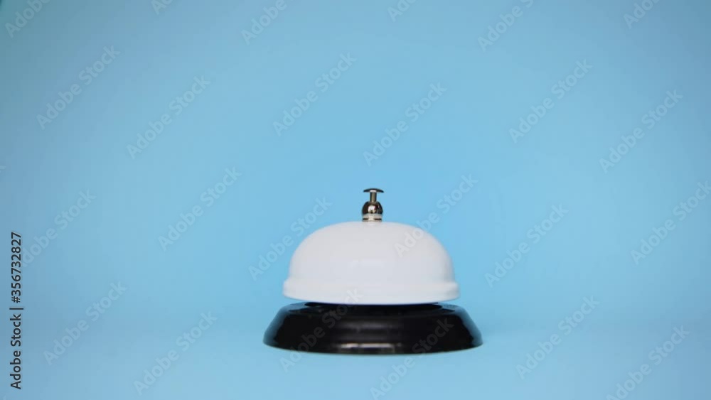 The hand presses reception call on a blue background. hotel service. The hand presses reception call on a blue background. hotel service.