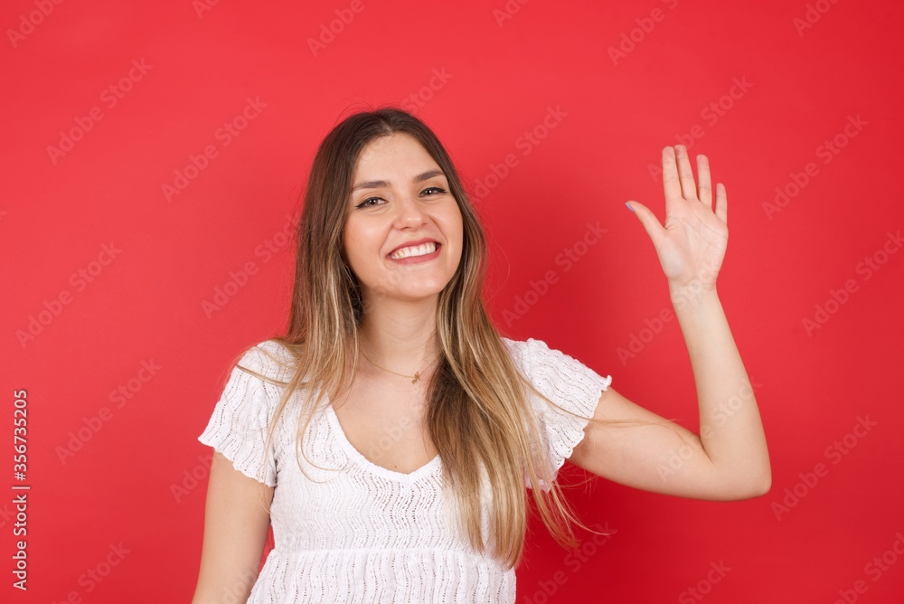 Young beautiful woman standing over yellow isolated background Waiving saying hello or goodbye happy and smiling, friendly welcome gesture Young beautiful woman standing over yellow isolated background Waiving saying hello or goodbye happy and smiling, friendly welcome gesture