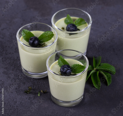 Fotografía Dessert cream Panna cotta with green tea matcha and blueberries in a glass on a