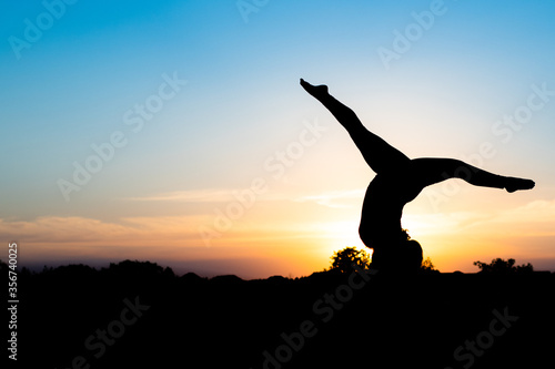 silhouette of woman doing yoga in the sunset
