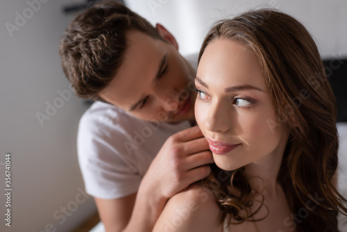 selective focus of handsome man touching beautiful girl