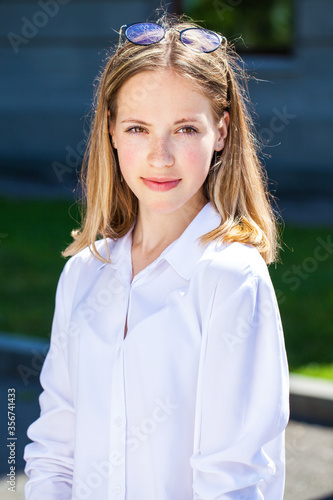 Portrait of a young beautiful girl in white shirt