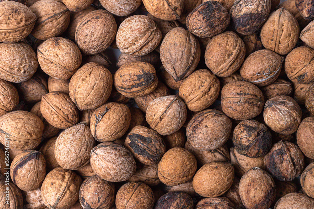 Scattered whole walnuts texture. Pattern, nuts background, texture close-up Scattered whole walnuts texture. Pattern, nuts background, texture close-up