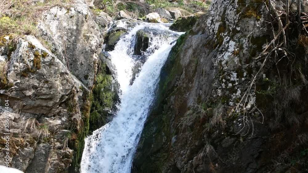 small waterfall in the mountains, Mountain waterfall, a waterfall on a small mountain river in early spring small waterfall in the mountains, Mountain waterfall, a waterfall on a small mountain river in early spring