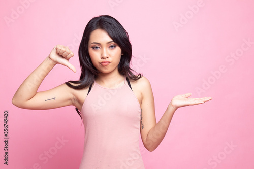 Young Asian woman show palm hand and thumbs down. © halfbottle