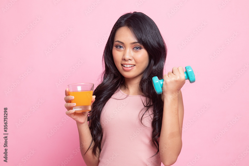 Young Asian woman with dumbbell drink orange juice. Young Asian woman with dumbbell drink orange juice.