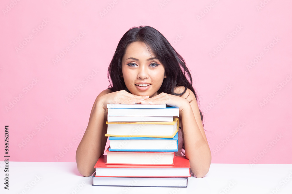 Happy young Asian woman read a book with books on table. Happy young Asian woman read a book with books on table.