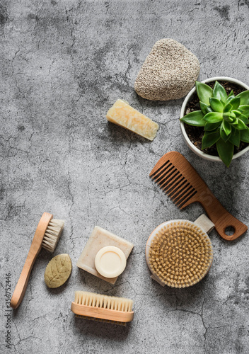 Body care health concept with copy space. Natural brushes, homemade soap, pumice stone, succulent flower on a gray background, top view
