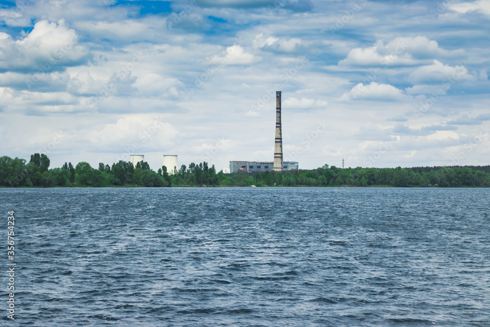 An old thermoelectric power station on the lake on a cloudy day