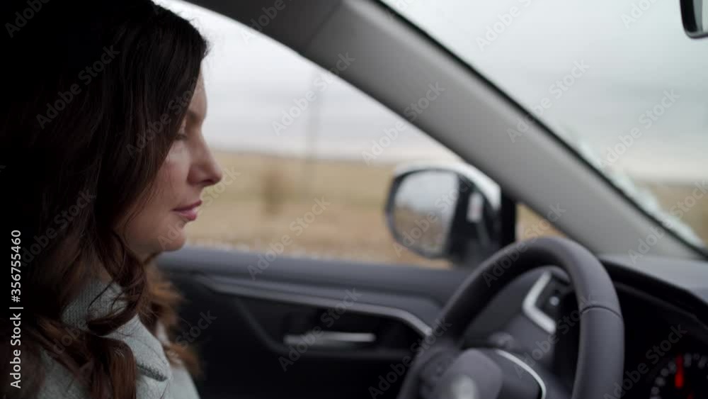 Brunette woman driver behind the steering wheel driving her crossover suv car Brunette woman driver behind the steering wheel driving her crossover suv car