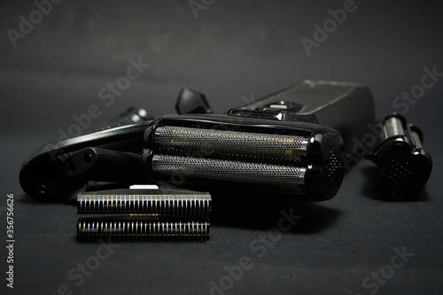 Fotografie Rechargeable electric shaver for men, black background.