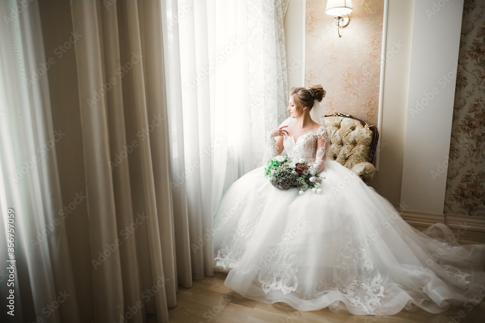 Luxury bride in white dress posing while preparing for the wedding ceremony Luxury bride in white dress posing while preparing for the wedding ceremony