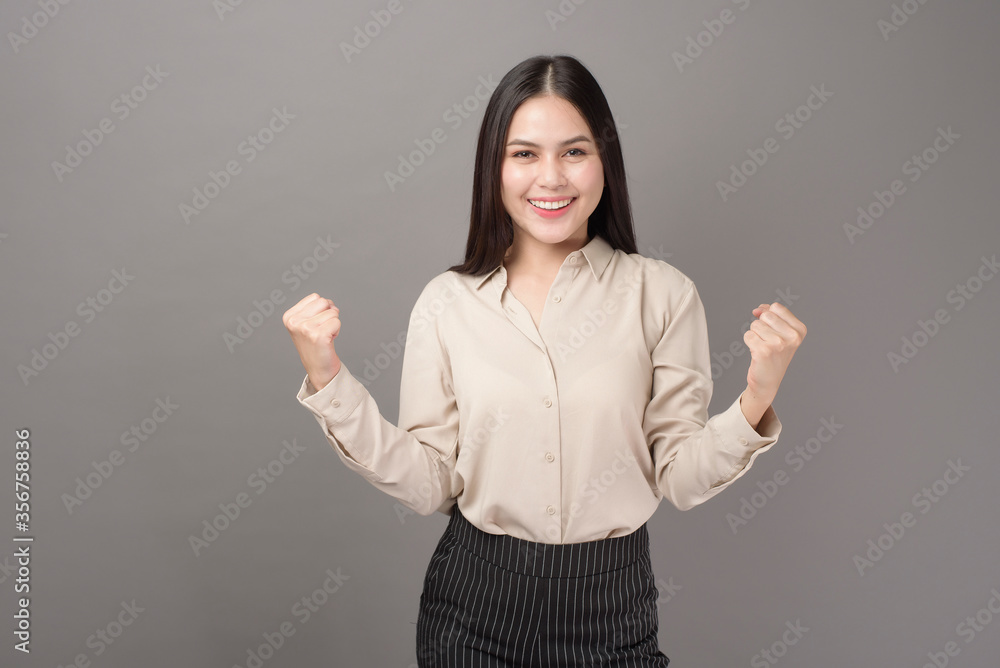 portrait of beautiful woman is happy with business successful on gray background portrait of beautiful woman is happy with business successful on gray background
