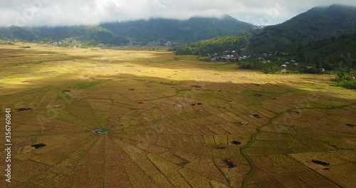 Stunning aerial day view of a spider rice paddy field near Ruteng town, with its cloudy sky on Flores island, famous travel destination in Indonesia and Asia