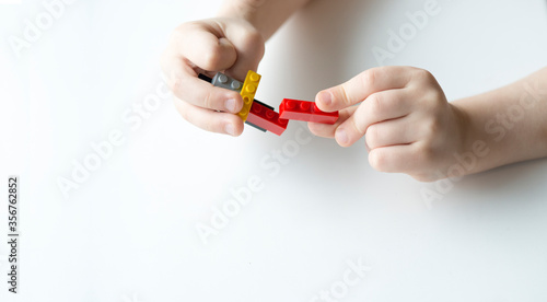 hands fingers boy playing Bricks isolated on white background copy space for text. Concept simple task. Child cope. motor skills. How to entertain child. Bright detail. Handle it. From simple to complex