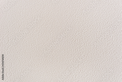 Textured background with decorative light stucco. Close-up image of a wall. Exterior finish of the facade with a rough coating.