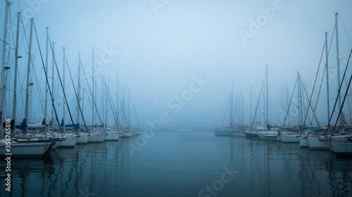 A dock with boats in heavy fog