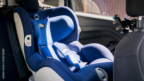 Empty blue baby car safety seat on car back seat at bright sunny day © Кирилл Рыжов