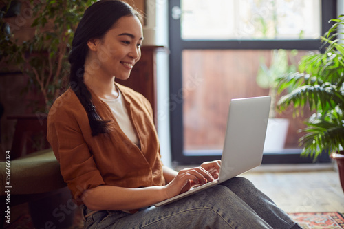 Concentrated female surfing the internet on a laptop