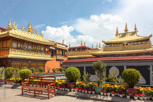 Jokhang temple gplden roof in Lhasa, Tibet from distance with a bench