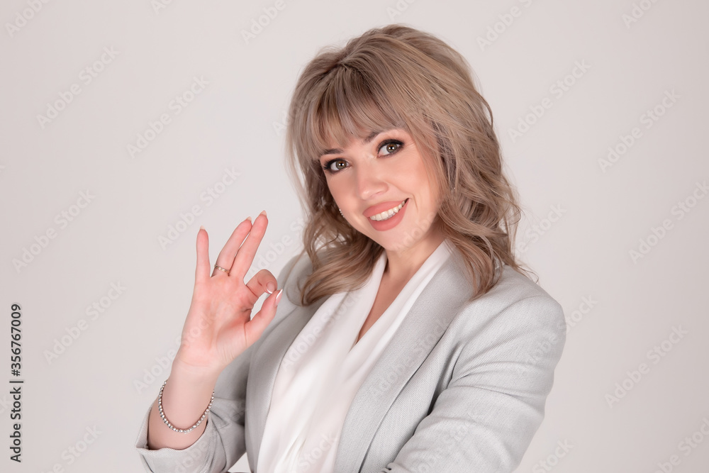 Portrait of woman business blonde in a bright jacket on a white grey background Portrait of woman business blonde in a bright jacket on a white grey background
