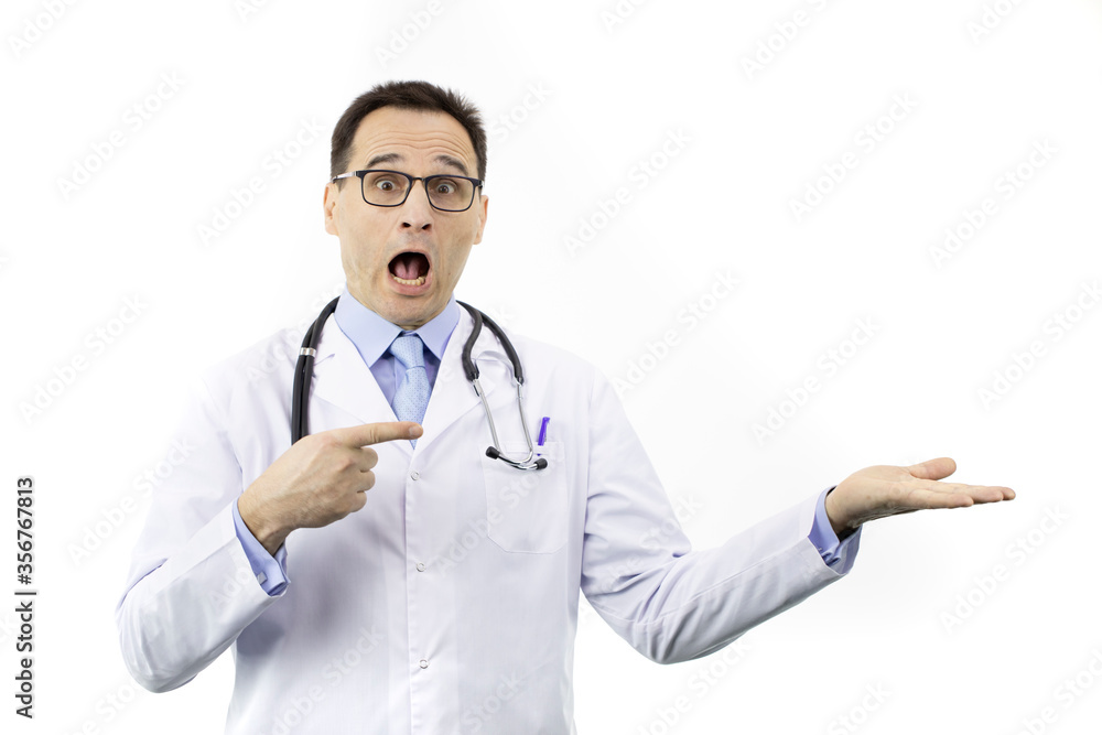 Shocked surprised doctor in medical coat and stethoscope points with finger to empty open palm holding ads product isolated on white background. Health, healthcare, insurance, medicine offer concept Shocked surprised doctor in medical coat and stethoscope points with finger to empty open palm holding ads product isolated on white background. Health, healthcare, insurance, medicine offer concept