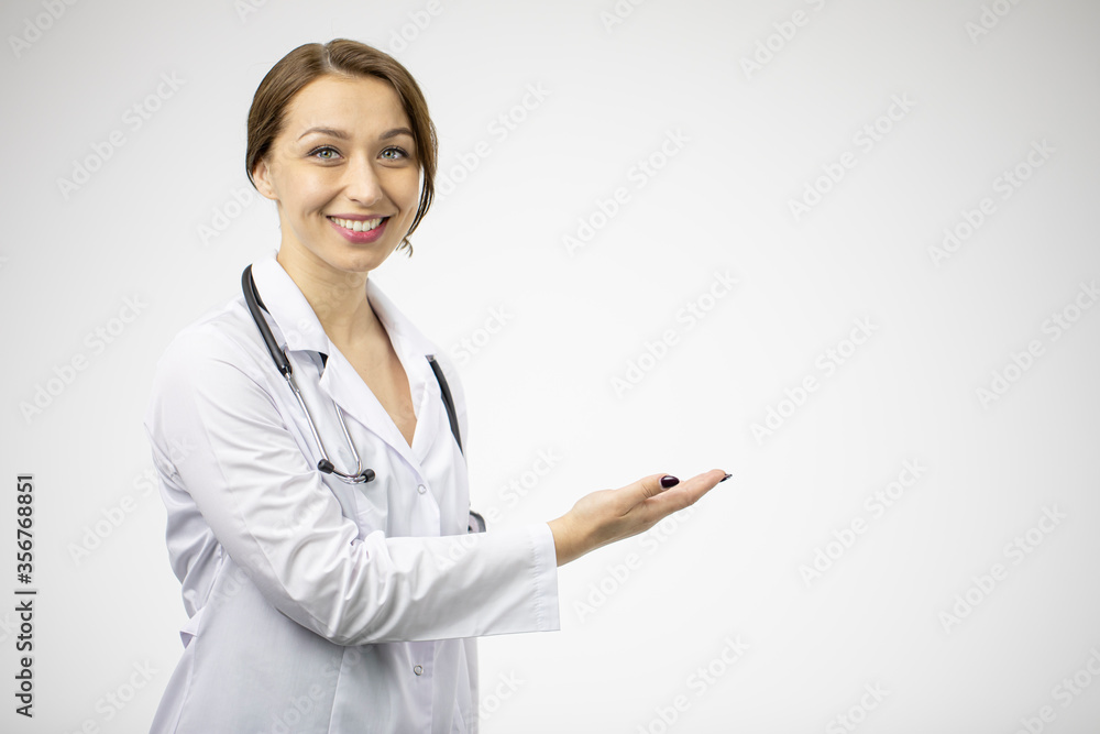 Excited beautiful female doctor in medical coat and stethoscope points to empty text space isolated on white background. Health, healthcare, insurance, clinic ads, medicine recommendation concept Excited beautiful female doctor in medical coat and stethoscope points to empty text space isolated on white background. Health, healthcare, insurance, clinic ads, medicine recommendation concept