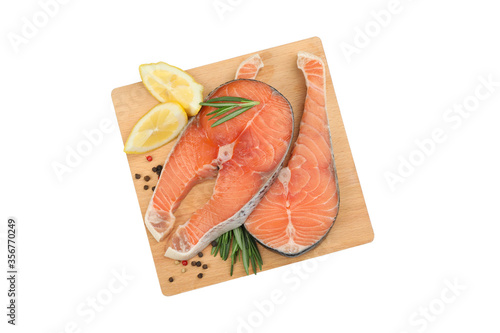 Board with salmon meat and spices isolated on white background