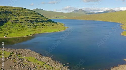 4K aerial - a bird's eye view video (Ultra High Definition) of Bosdalafossur waterfall. Bright summer scene of Sorvagsvatn lake, Vagar, Faroe Islands, Kingdom of Denmark, Europe. 
