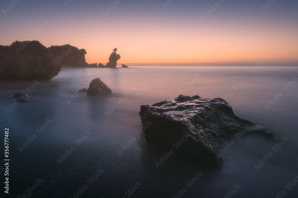 Quiet twilight on the sea coast. Calm sea, picturesque rocks and cloudless golden sky. Peace, silence, meditation. Copy space on the golden sunset sky. Quiet twilight on the sea coast. Calm sea, picturesque rocks and cloudless golden sky. Peace, silence, meditation. Copy space on the golden sunset sky.