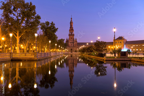 North Tower and Canal - A wide-angle dawn view of the north tower of Plaza de Espa  a  reflected in the calm water of the canal  on a clear Autumn morning. Seville  Andalusia  Spain.