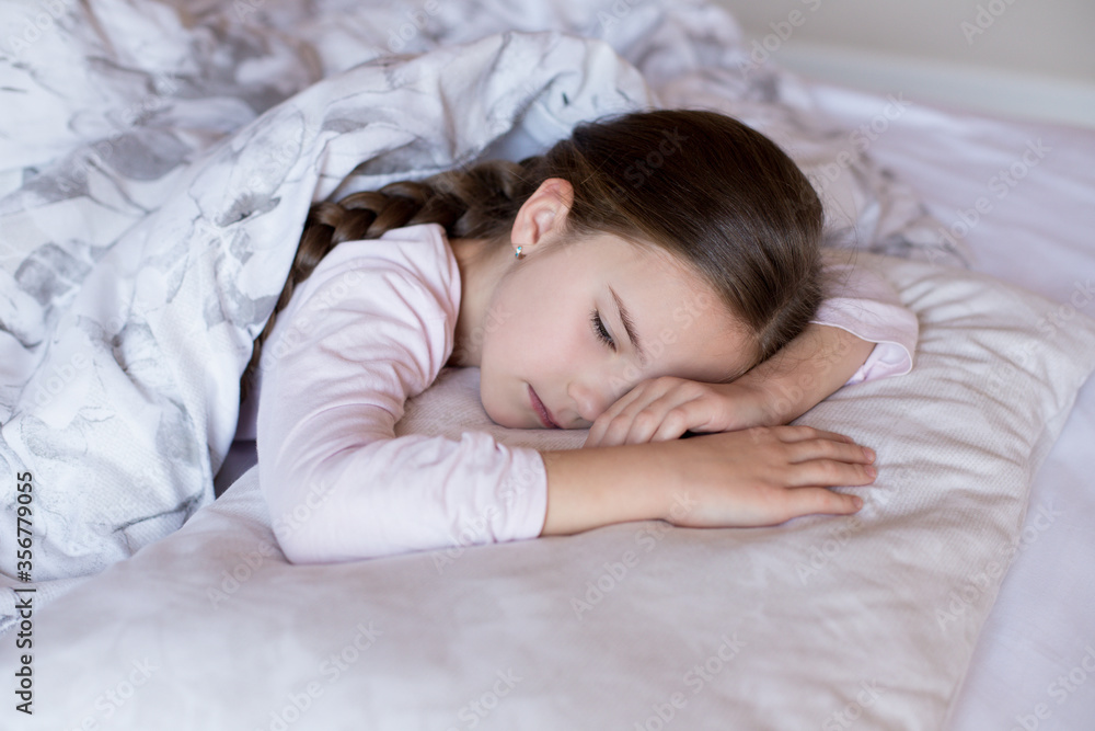 Sick little girl lies in bed on a pillow and is sad Sick little girl lies in bed on a pillow and is sad