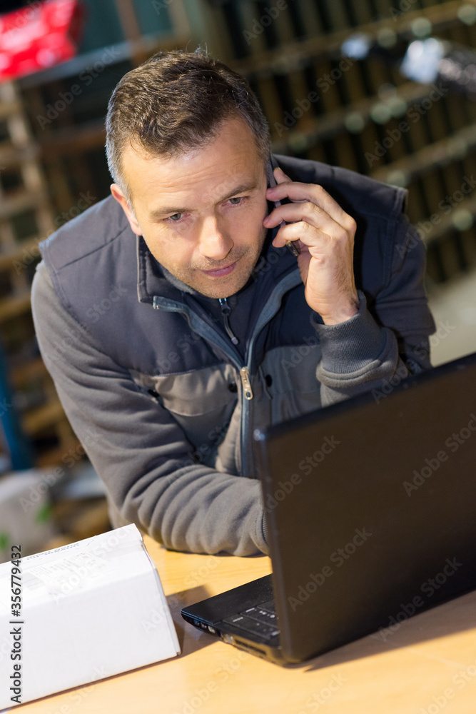 businessman using a laptop in a warehouse businessman using a laptop in a warehouse