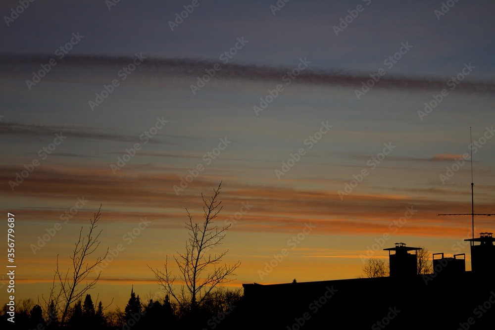 Silhouette of building with yellowish orange twilight sky in the background