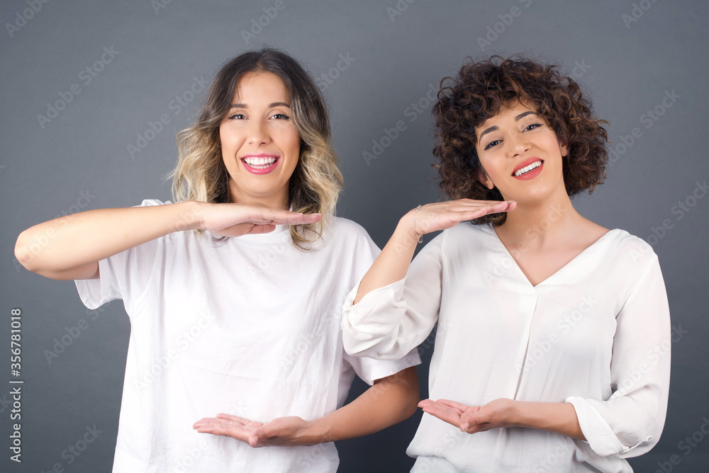 Blonde European woman over isolated background gesturing with hands showing big and large size sign, measure symbol. Smiling looking at the camera. Measuring concept. Blonde European woman over isolated background gesturing with hands showing big and large size sign, measure symbol. Smiling looking at the camera. Measuring concept.